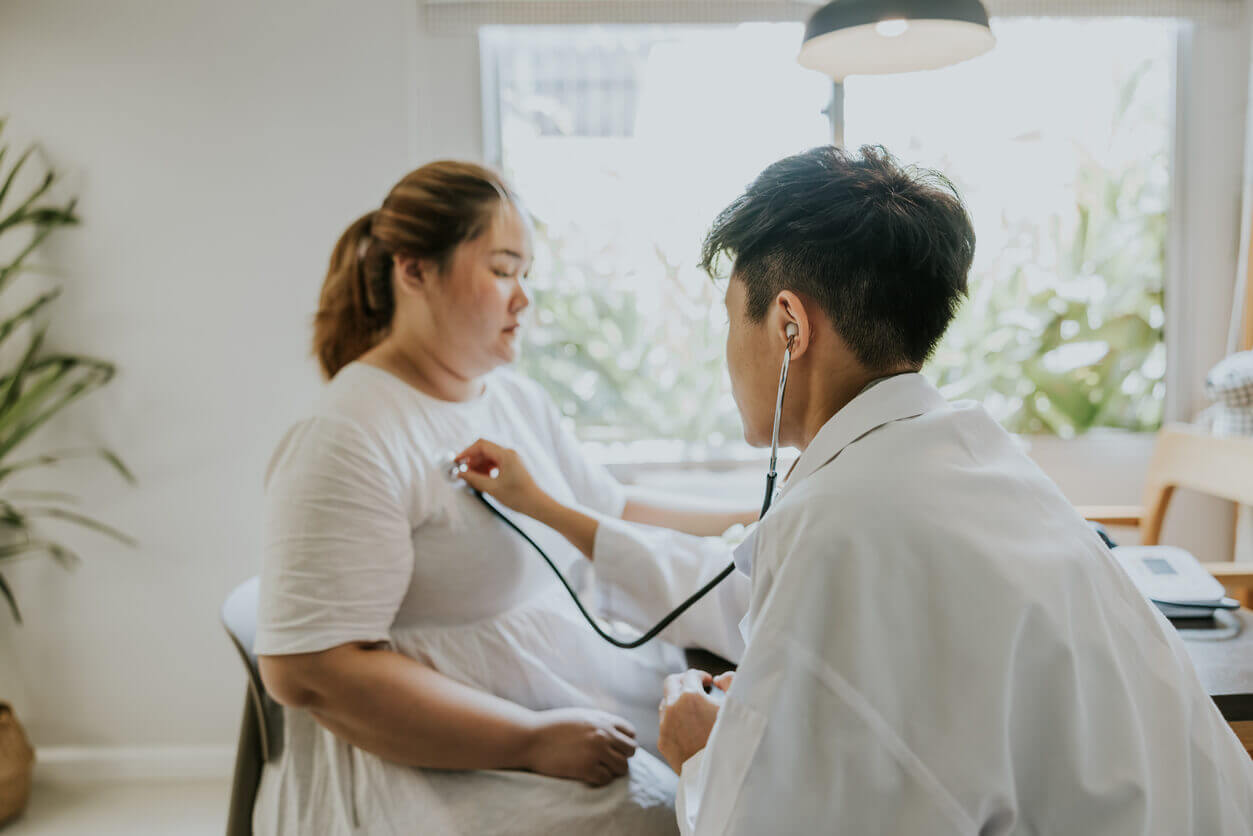 Transgender male doctor doing medical exam to obesity patient at home