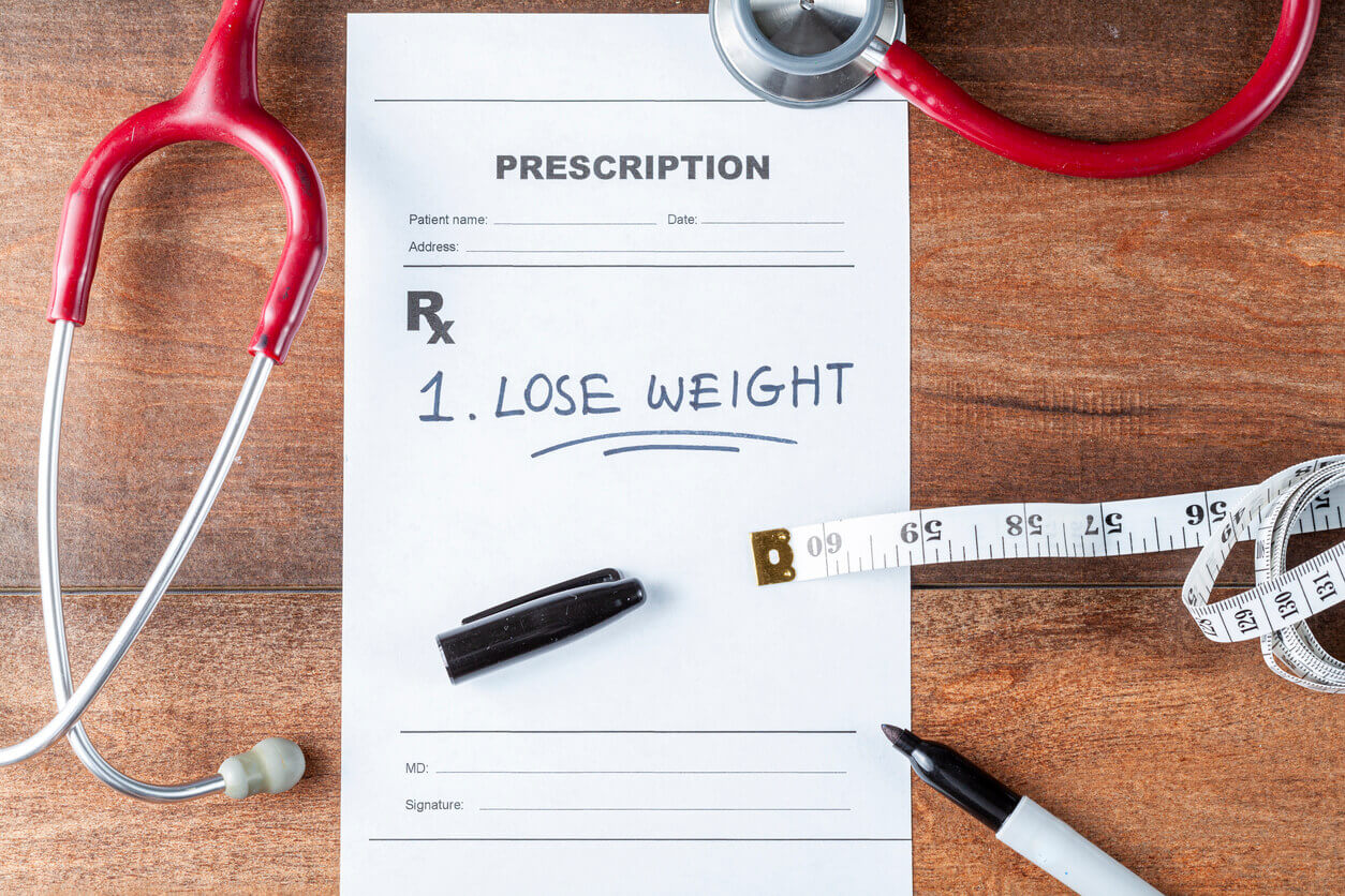 An image illustrating the concept of weight loss, featuring a prescription and a tape measure on a desk.
